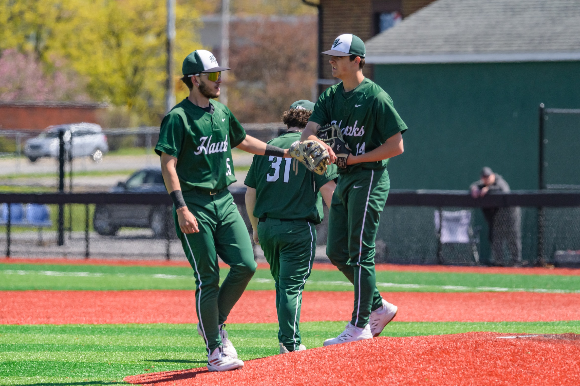 Hawks pitcher and player high five before starting the game.